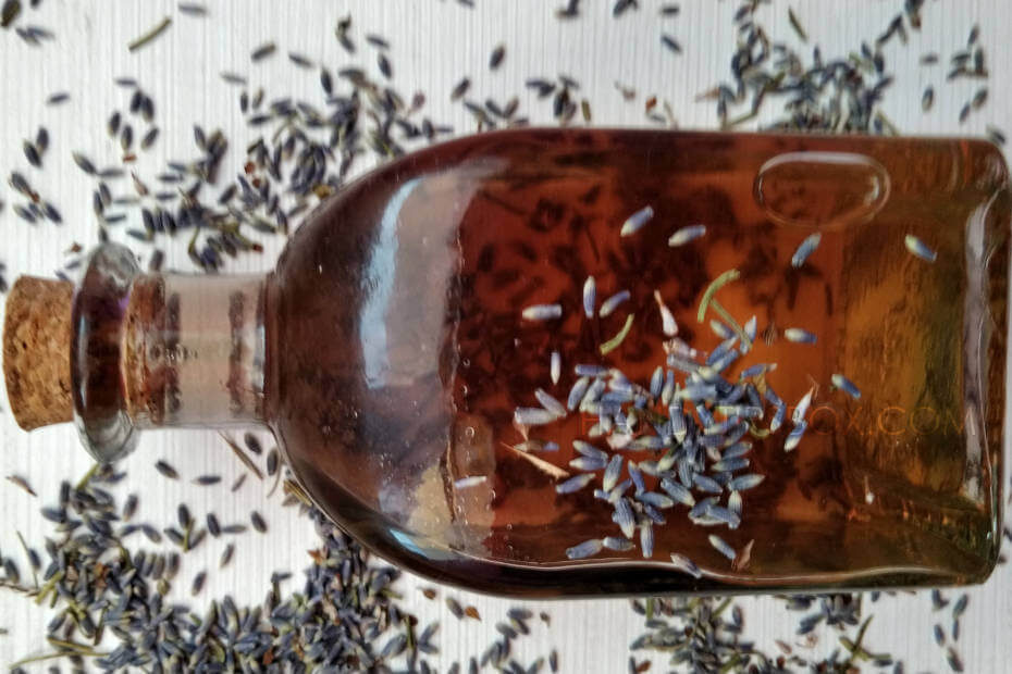 Homemade lavender facial toner in a bottle with cork and dried lavender buds